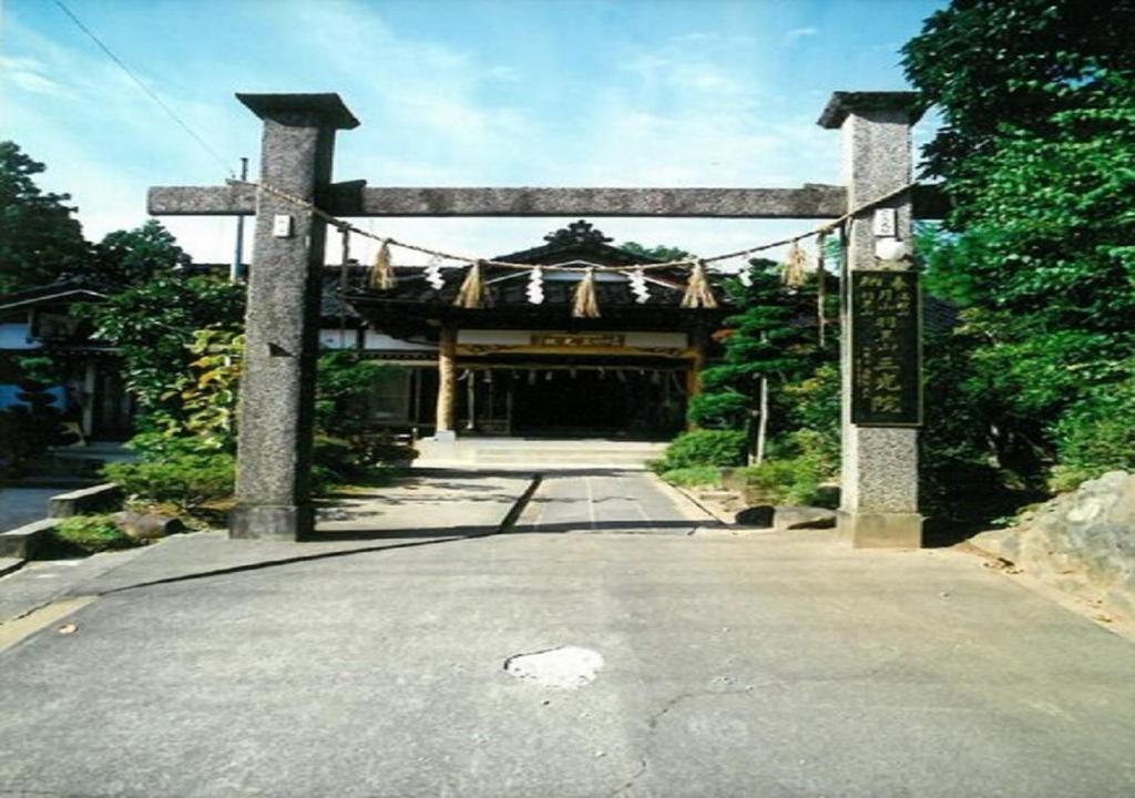 an entrance to a temple with a gate and a road at Hagurosan Sankouin / Vacation STAY 40373 in Tsuruoka