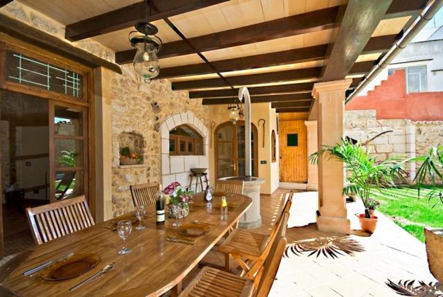 a wooden table and chairs on a patio at Villa Can Bassa Muro in Muro