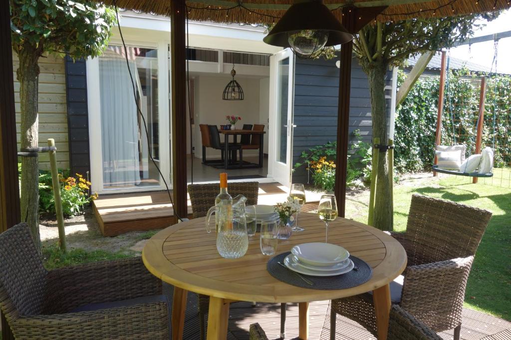 a wooden table with plates on it on a patio at Albatros in Schoorl