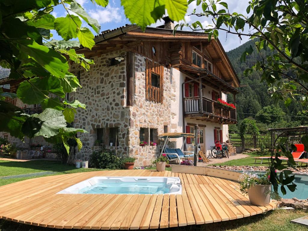 una casa con terraza de madera frente a una casa en Maso Franceschella en Carano