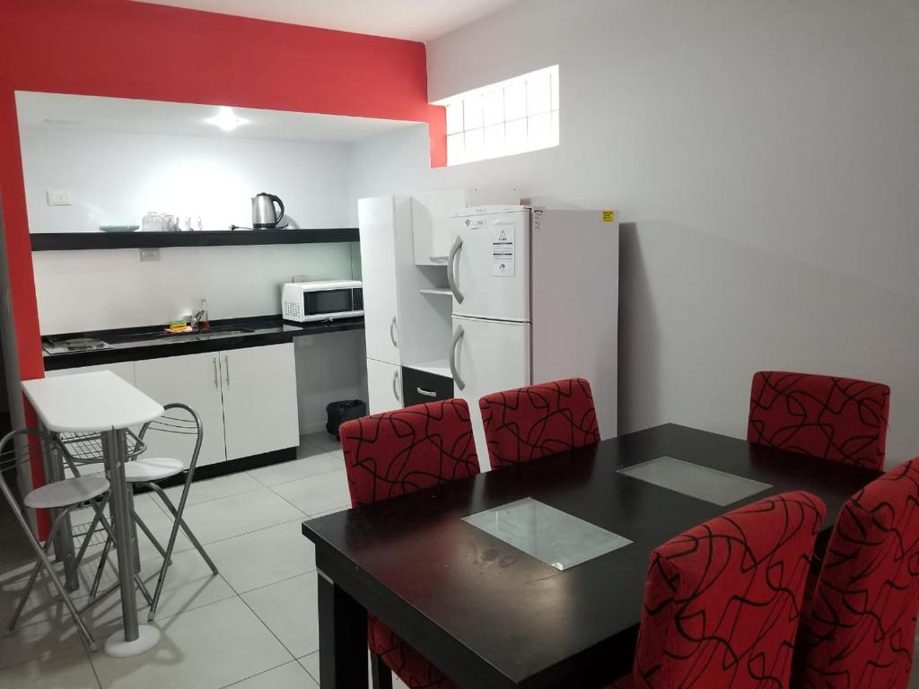 uma cozinha com uma mesa e cadeiras e um frigorífico em San Remo Apartments em Buenos Aires