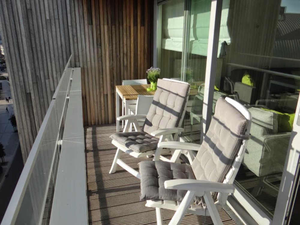 2 chaises et une table sur un balcon dans l'établissement A La Ferme, à La Panne