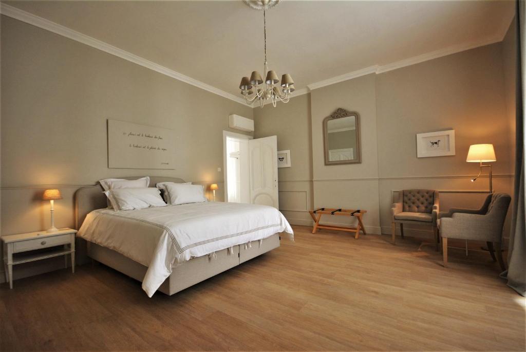 1 dormitorio con 1 cama, 1 silla y 1 lámpara de araña en Villa de Noailles, en Spa