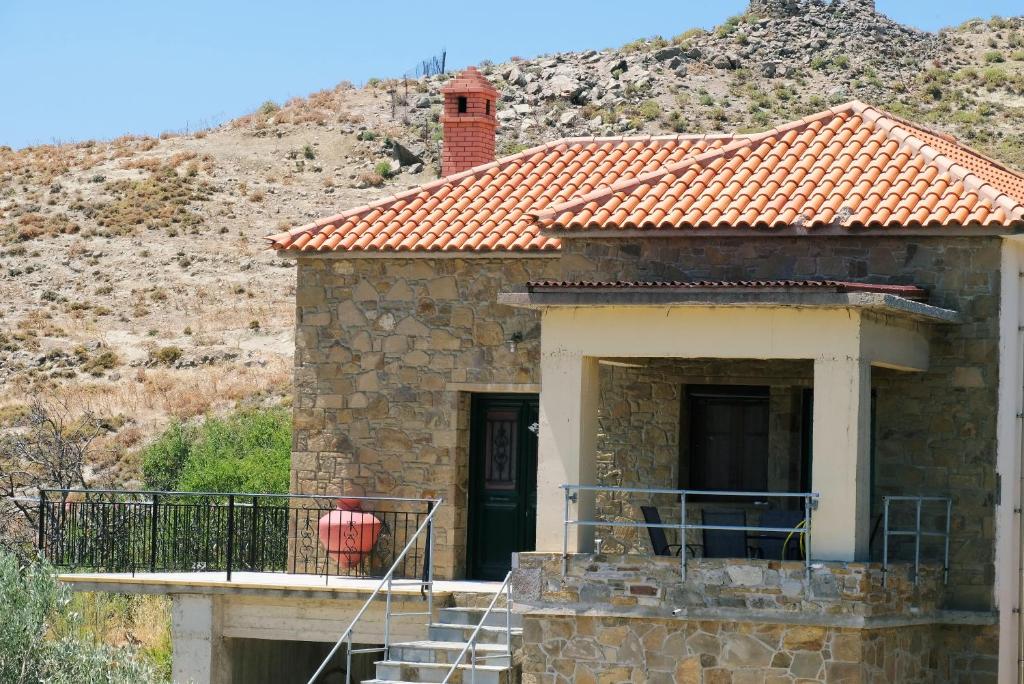 Stone House Of Panos في Kornós: منزل حجري صغير بسقف احمر