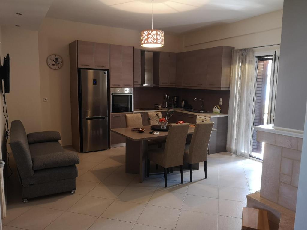 a kitchen with a table and chairs and a dining room at Eleni Apartment in Perdhika