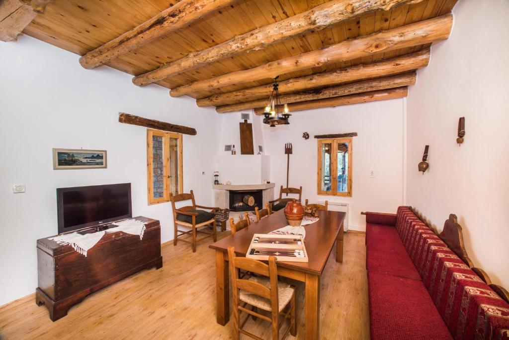 a living room with a table and chairs and a television at ARADENA TRADITIONAL House 1 in Arádhaina