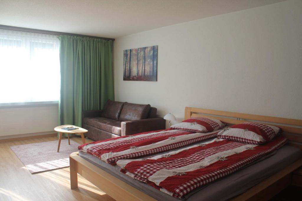 a bedroom with a large bed and a couch at Ferienwohnung Alpenblick in Davos