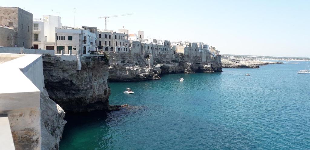 a large body of water with buildings and boats in it at Casa Nori in Polignano a Mare