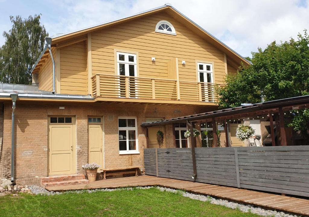 a house with a wooden deck and a balcony at Taevas Külalistemaja in Võru