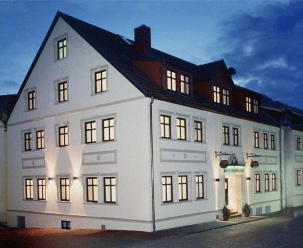 ein großes weißes Gebäude mit eingeschaltetem Licht in der Unterkunft Hotel Stadt Waren in Waren (Müritz)