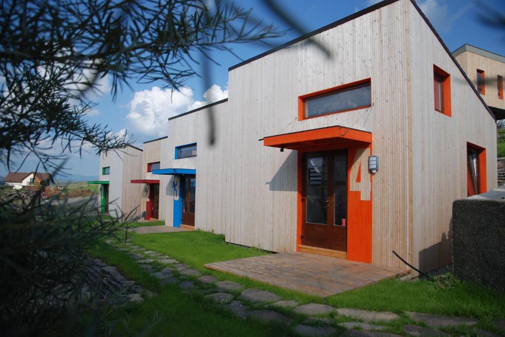 un edificio con una puerta naranja a un lado en Bungalouri Horizont, en Odorheiu Secuiesc