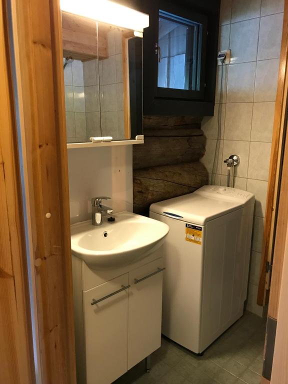 ein kleines Bad mit einem Waschbecken und einem Kühlschrank in der Unterkunft Chill Cave - logwood cottage in Ruka