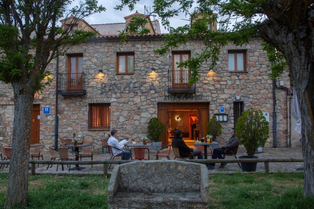 a group of people sitting at tables in front of a building at Hostal Bavieca in Medinaceli