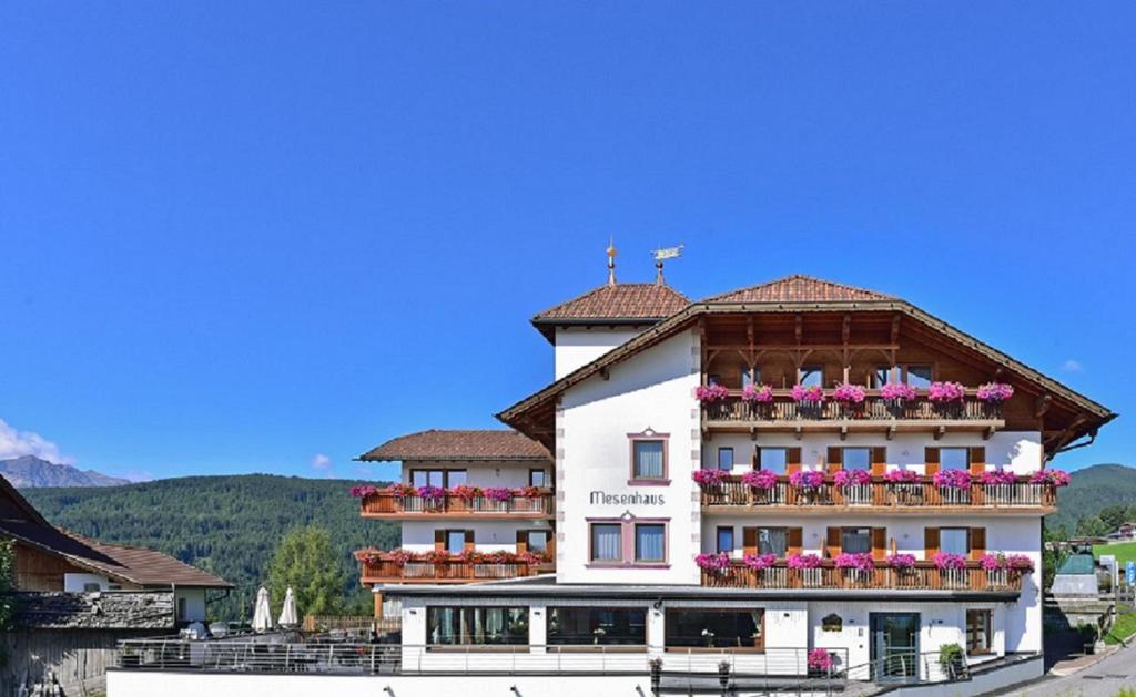 um grande edifício branco com flores nas varandas em Holiday Residence Mesenhaus em Maranza