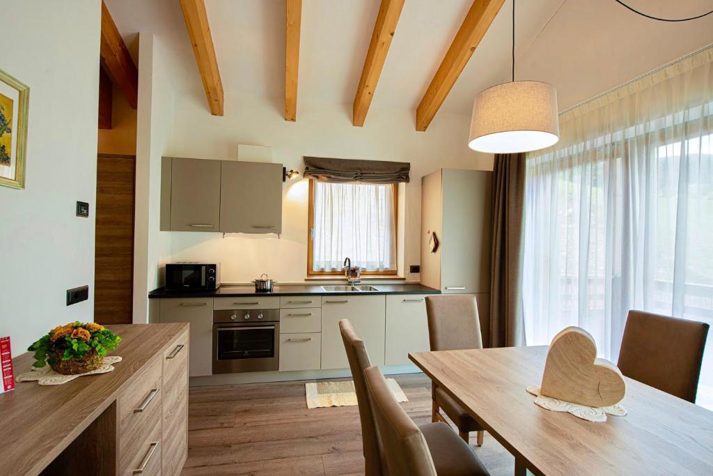 een keuken en eetkamer met een houten tafel bij CIMA 11 & SASS PORDOI - Apartments in Moena