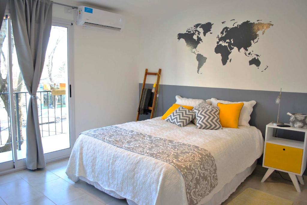 een slaapkamer met een bed met een wereldkaart aan de muur bij El Balconcito Monoambiente in Saladillo