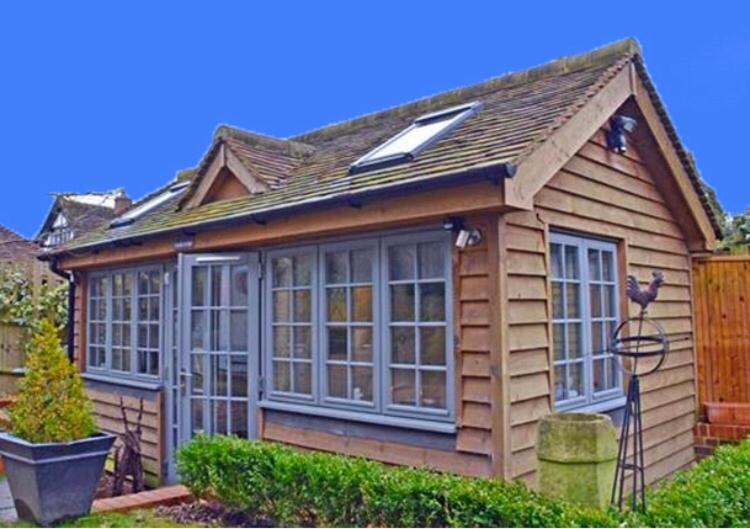 uma casa pequena com muitas janelas em Truffle Lodge em Lindfield