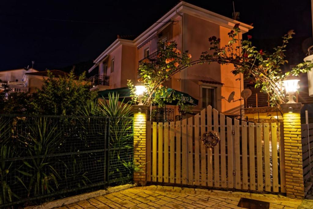 a white fence in front of a house at night at ANEMOS in Parga