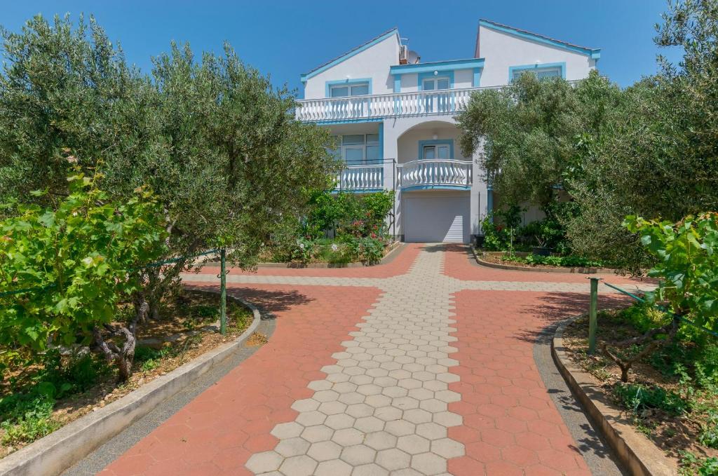 a house with a walkway in front of it at Apartments Rosanda in Pirovac