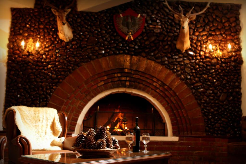 a room with a brick fireplace with a table and a fire place at Hotel Gramado Palace in Gramado