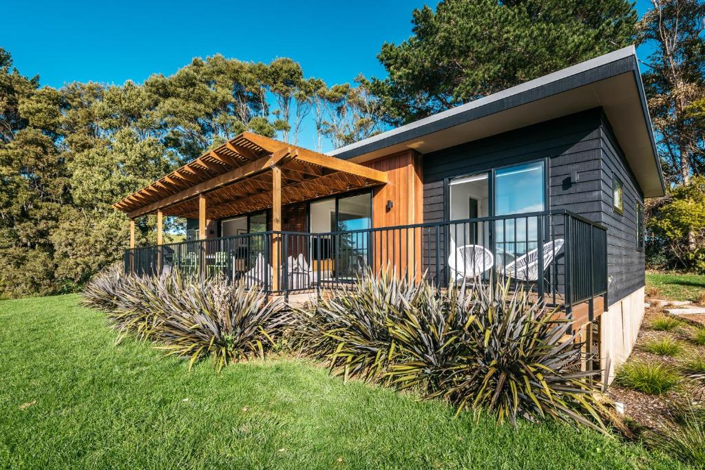 a modular home with a deck and lawn at Tui Villa at Putaki Bay in Te Whau Bay