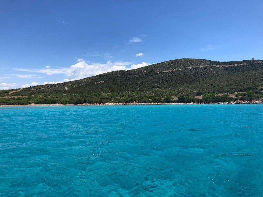 a large body of water with a mountain in the background at Acquamaris Tuerredda in Teulada