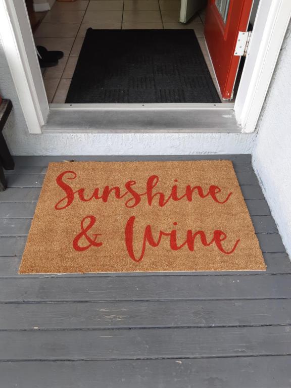 a door mat with the words sunshine and wine on it at Sunshine and Wine Loft in Penticton