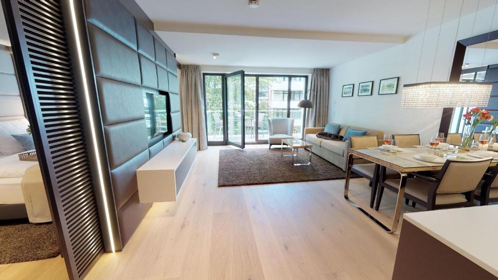 un salon avec une table à manger et une chambre avec un canapé dans l'établissement White Pearl Apartment 2.12, à Timmendorfer Strand