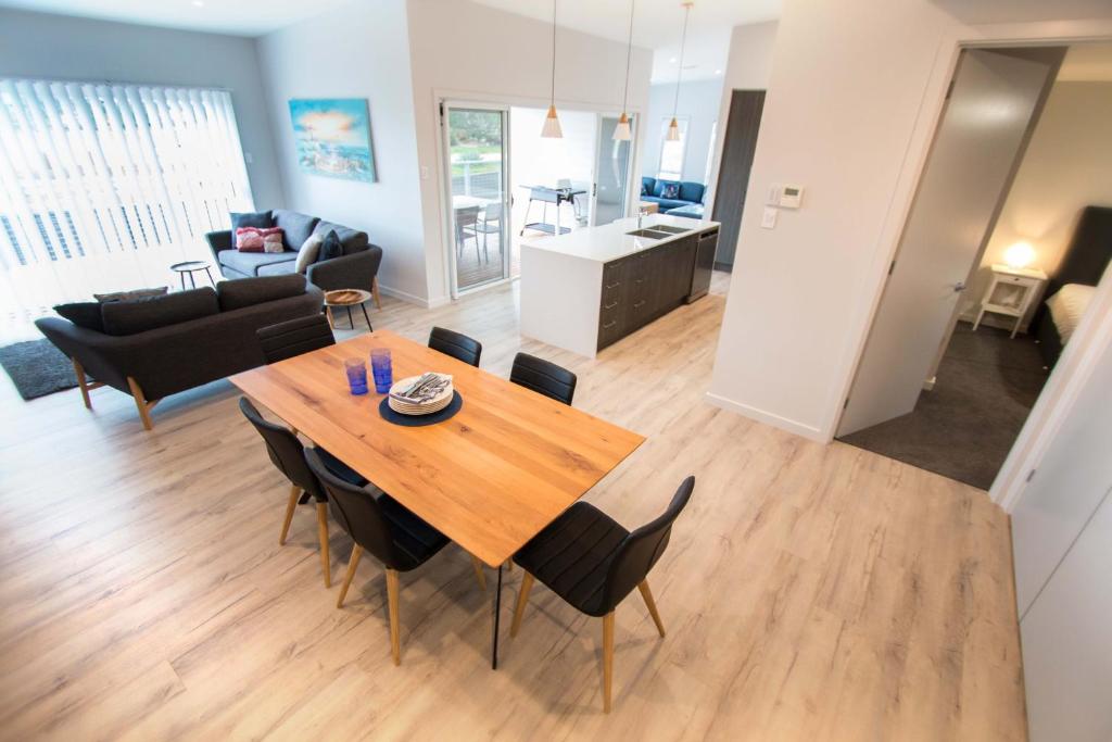 a dining room and living room with a table and chairs at Wellington Lake Retreat in Wellington East