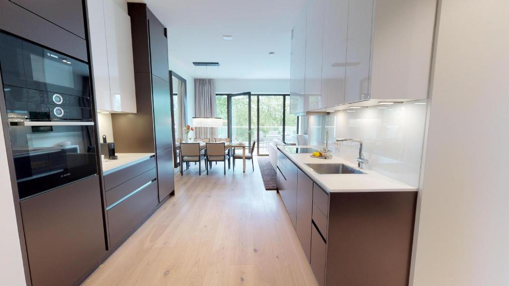 cocina con armarios blancos y comedor en White Pearl Apartment 4.20, en Timmendorfer Strand