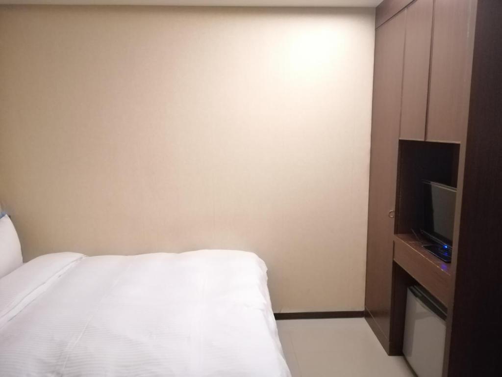a hotel room with a bed and a tv at Shan-Yue Hotspring Hotel in Taipei
