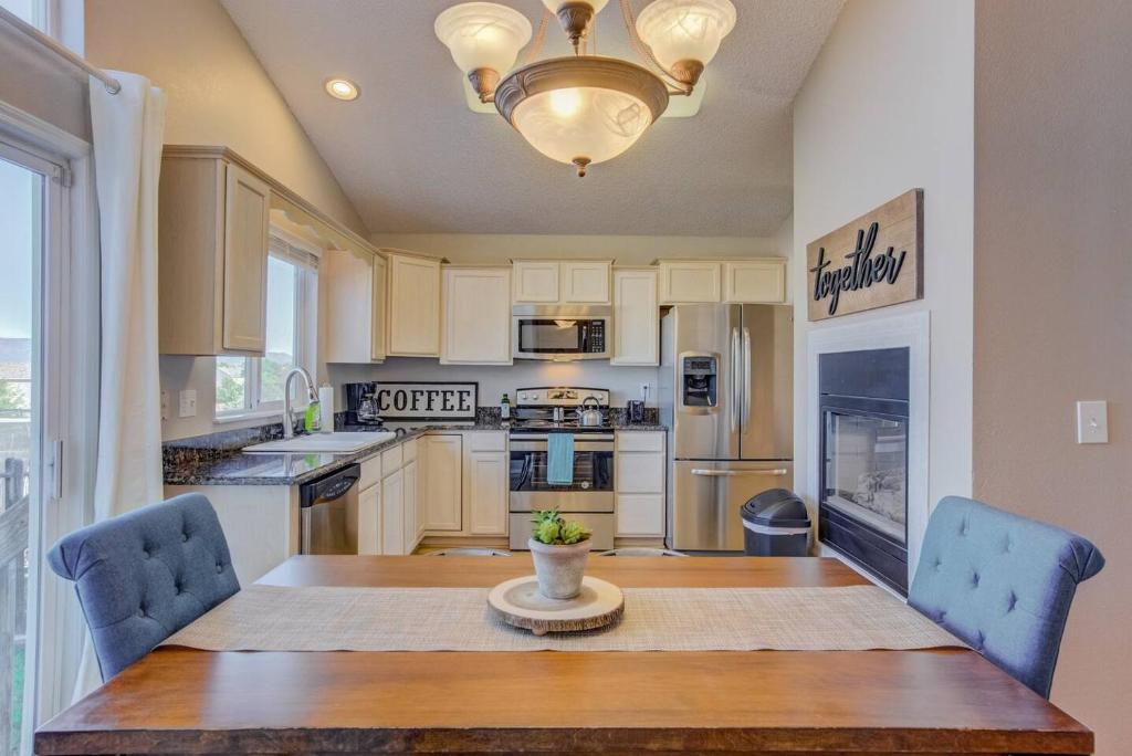 a kitchen with a wooden table and blue chairs at Cozy 4BR House with Peak Views in Colorado Springs in Colorado Springs