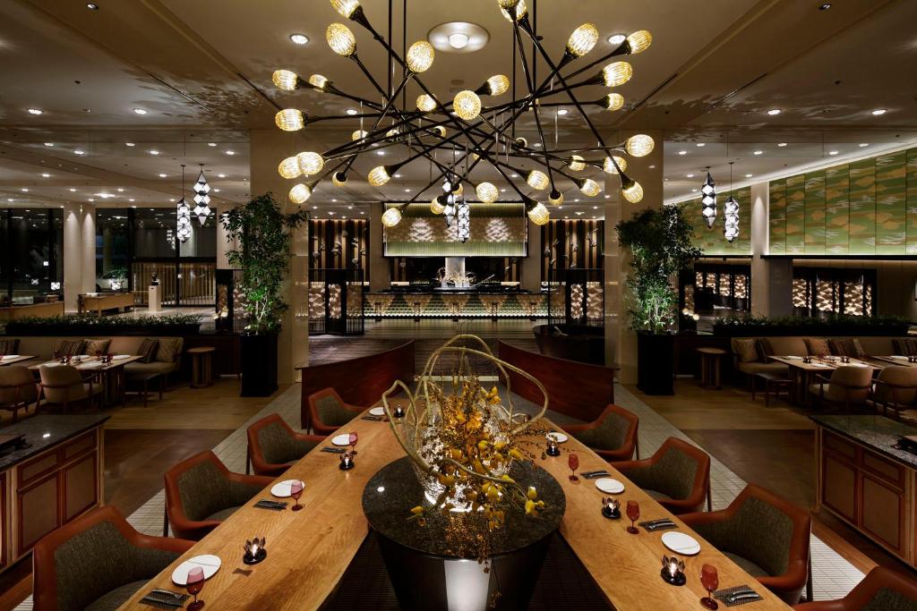 a dining room with a long table and a chandelier at Grand Prince Hotel Shin Takanawa in Tokyo