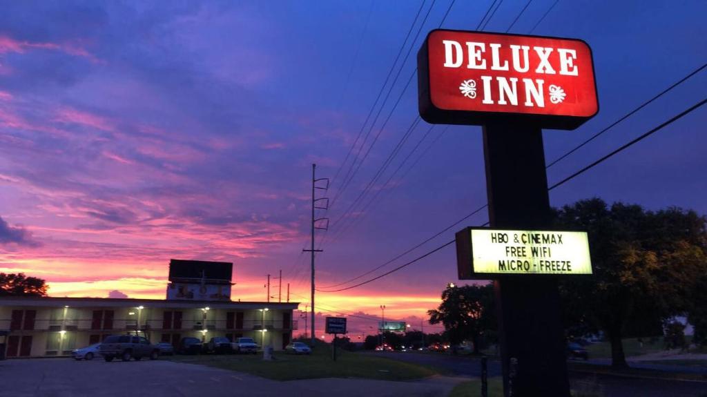 a sign for a delivelling inn in front of a building at Deluxe Inn in Natchez