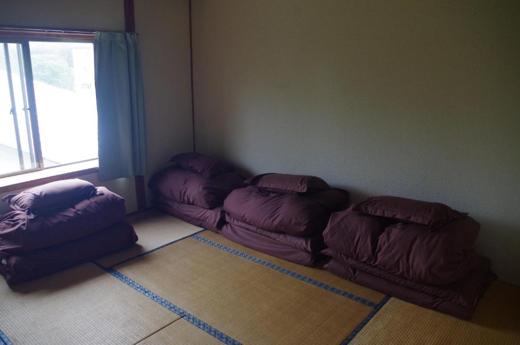 a room with three bean bags in a room with a window at Kusatsu Onsen Guesthouse Gyoten in Kusatsu