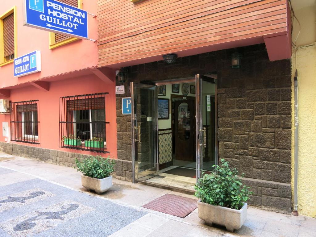 una entrada a un edificio con dos macetas delante en Hostal Guillot, en Torremolinos