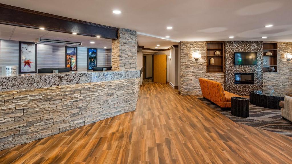 a lobby of a hotel with a stone wall at Best Western Plus Country Meadows Inn in Aldergrove