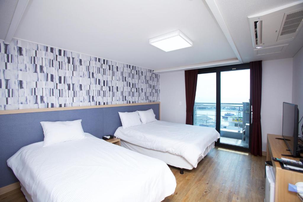 Postel nebo postele na pokoji v ubytování Jeju Moseulpo Hotel