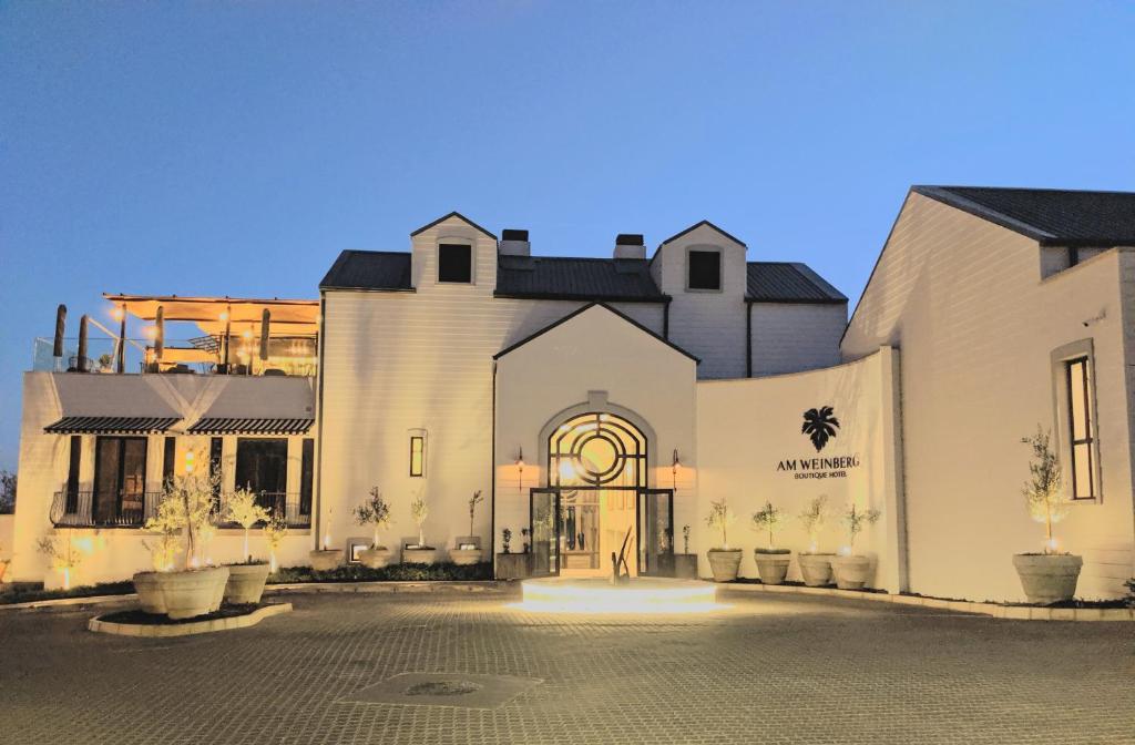 um grande edifício branco com um pátio em frente em The Weinberg Windhoek em Windhoek