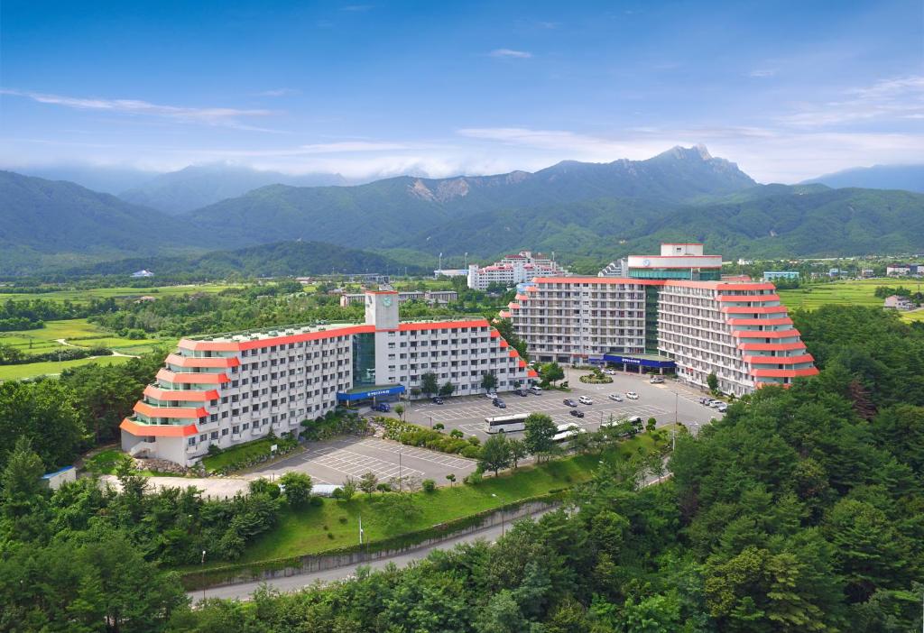 an aerial view of a building with mountains in the background at Hyundai Soo Resort Sokcho in Sokcho
