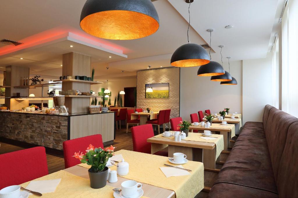 a restaurant with wooden tables and red chairs at Hotel Silberhorn in Nürnberg