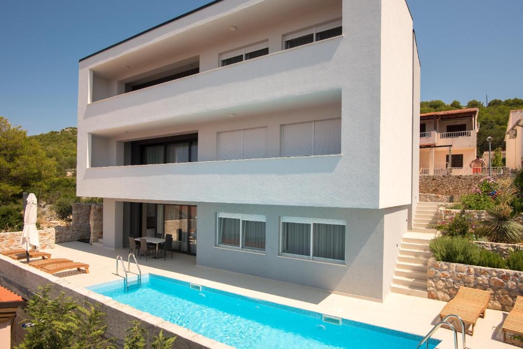 eine Villa mit einem Pool und einem Haus in der Unterkunft White Rock Villa Kaprije in Kaprije