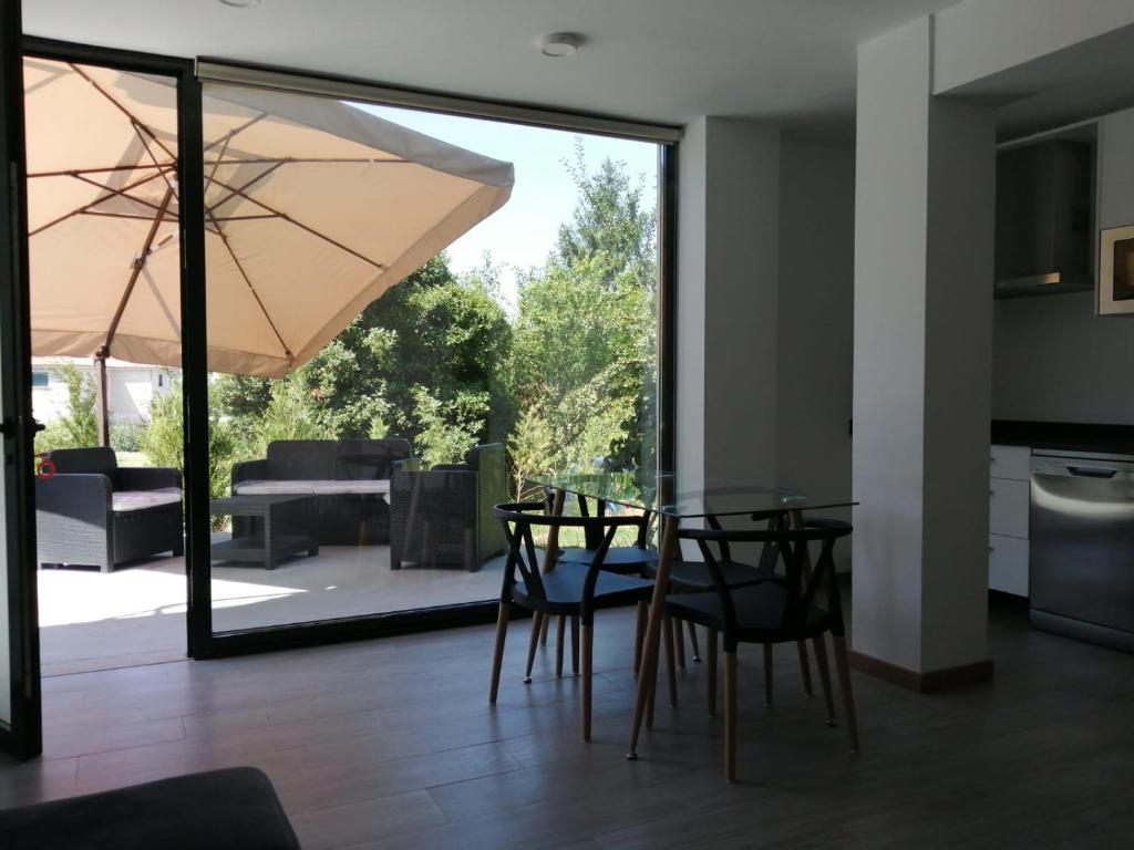 a dining room with a table and chairs and a patio at Precioso apartamento vacaciones en zona Ramallosa in Baiona
