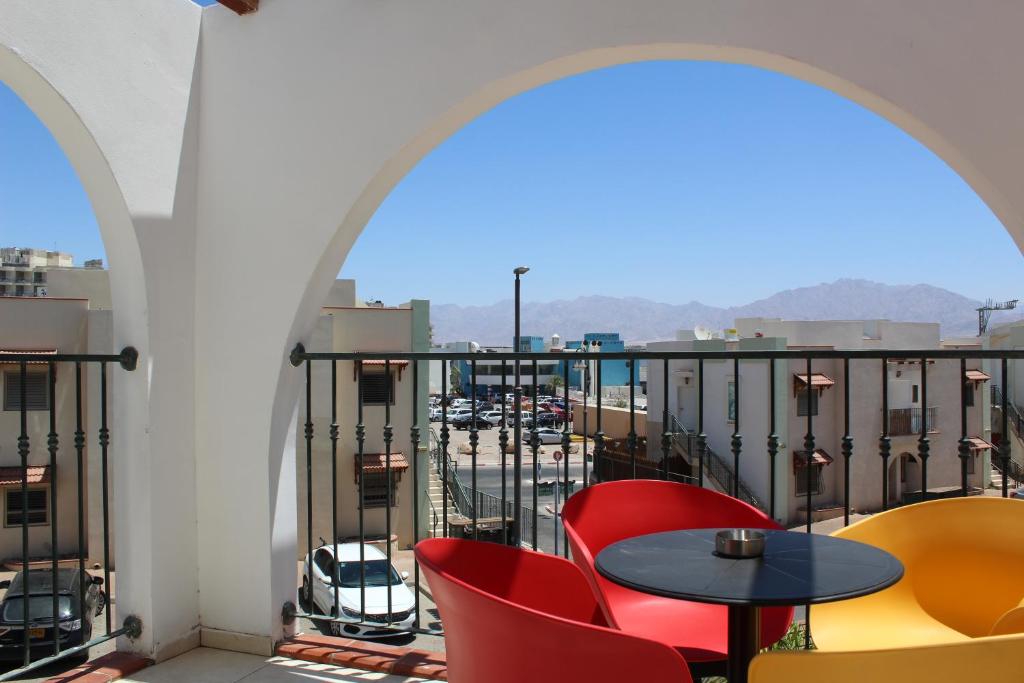 uma varanda com mesas e cadeiras e vista para a cidade em North Shore Apartment em Eilat