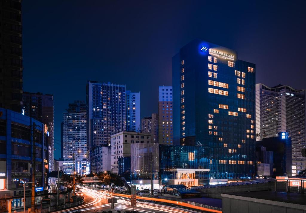 een stad verlicht in de nacht met auto's bij Chongqing Liyuan Hotel in Chongqing