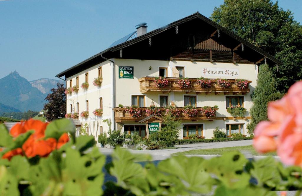 a building with flowers in front of it at Pension Rega in St. Wolfgang