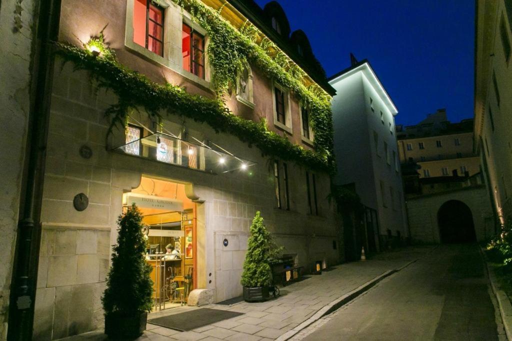 un edificio con piante sul lato di esso di notte di Hotel Gródek a Cracovia