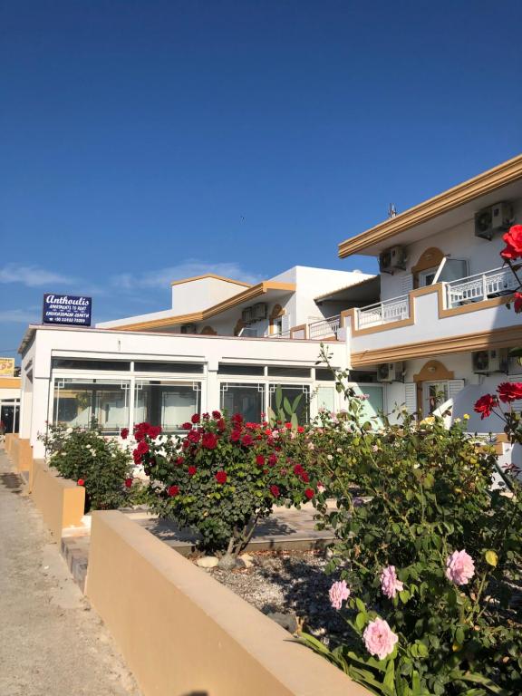 Un bâtiment blanc avec des fleurs devant lui dans l'établissement Anthoulis Studios, à Kefalos