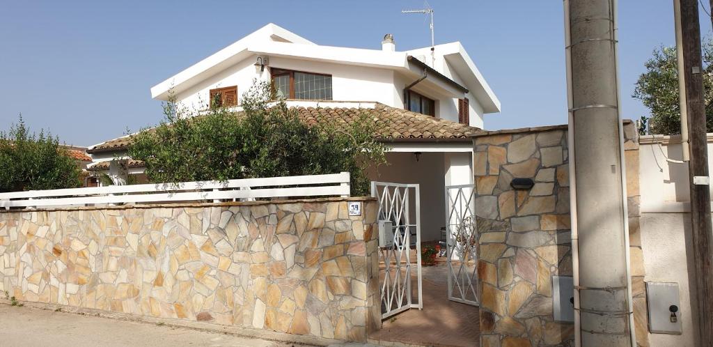 una casa blanca con una pared de piedra y una valla en Villa Amanda, en Mazara del Vallo