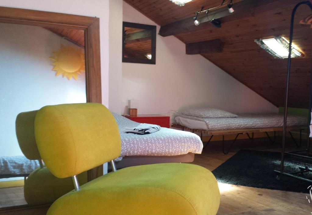 Habitación con cama y silla amarilla en h2oholidays - auberge de jeunesse - youth hostel, en Capbreton